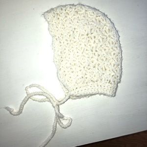 Hand knit baby bonnet in a creamy white color